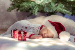 sleeping baby under christmas tree