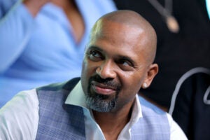 Mike Epps at IMDb At Toronto 2019 Day 2 smiling looking left wearing a vest and dress shirt.