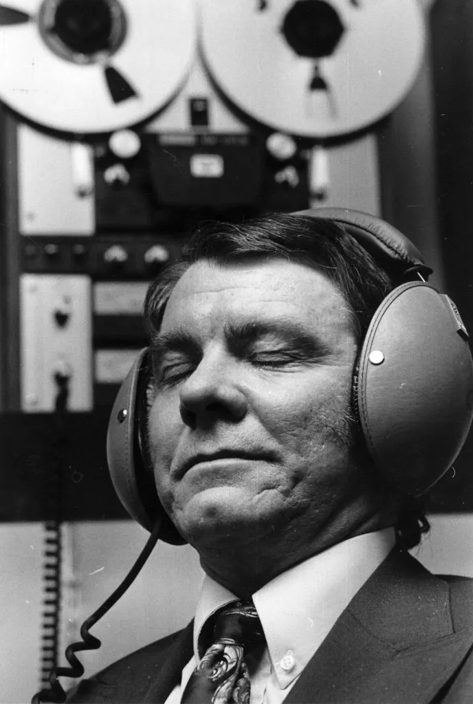 A man listening to music through headphones with his eyes closed.