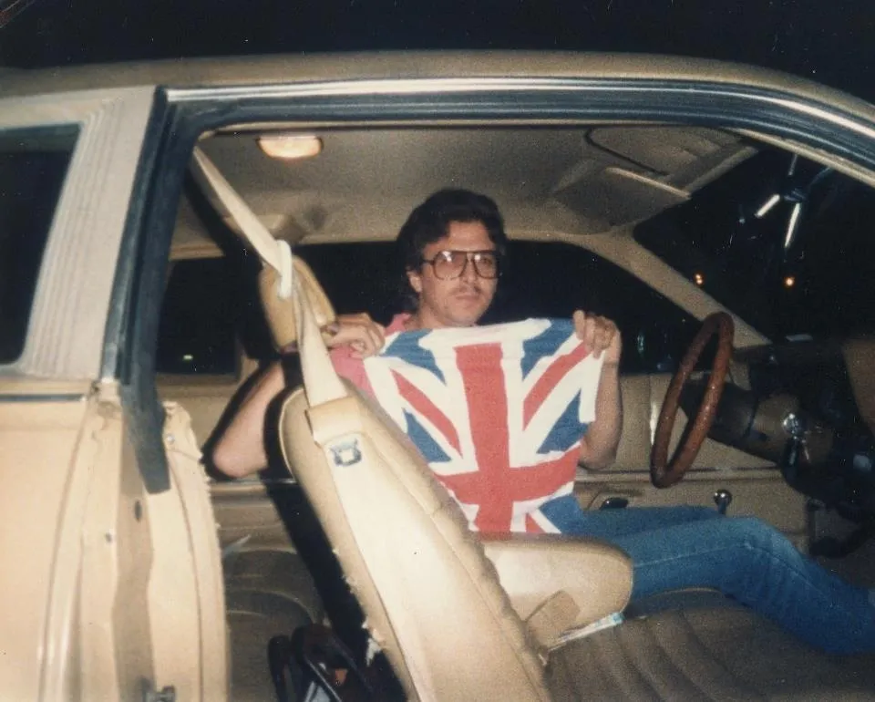 eric johnson in the 80s holding up a short with a union jack on it