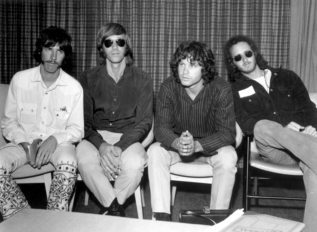 The Doors sit in chairs at a press conference.
