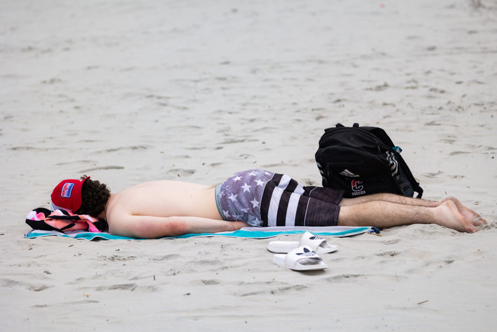 A person sleeps on the beach during the Memorial Day weekend  - Jersey Shore